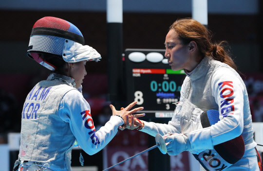 20일 오후 자카르타 컨벤션센터에 열린 2019 2018 자카르타-팔렘방 아시안게임 여자 2018 자카르타-팔렘방 아시안게임 펜싱 여자 플뢰레 경기. 16강전에서 맞붙은 남현희(왼쪽)와 전희숙이 양보 없는 승부를 펼친 뒤 악수하고 있다.  연합뉴스